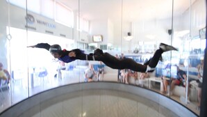 A person performing a backflip on a trampoline in a public indoor space with glass walls and a visible sign that reads "WIMBLEDON". - Pleasant one bedroom apartment (Empuriabrava)