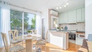 A modern kitchen with a central island, a dining area with chairs, and a sofa. - Pleasant one bedroom apartment (Empuriabrava)