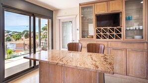Una cocina moderna con encimera de mármol, armarios de madera y un botellero.