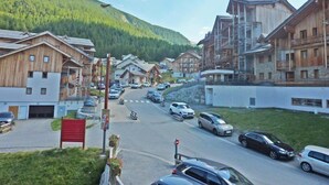 A mountain resort with wooden buildings, a main road, and a parking area. - 2222 LES Silenes 1800 (LES ORRES 1800)