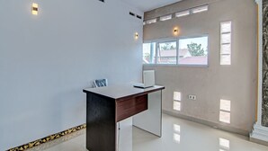 A modern office space with a desk, a laptop, and a window with blinds. - Hotel O Elisa Hill (Pangkalan Kerinci)