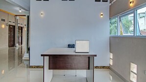 A modern hotel room with a minimalist design, featuring a large window, a desk with a laptop, and a clean, reflective floor. - Hotel O Elisa Hill (Pangkalan Kerinci)