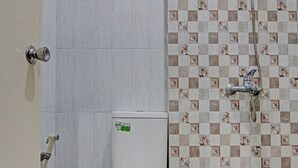 A bathroom with a toilet, a shower, and a tiled floor. - Hotel O Elisa Hill (Pangkalan Kerinci)