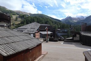 Un bâtiment rustique, doté d’une façade en bois et d’un toit en métal, entouré d’un paysage montagneux.