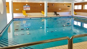 An indoor swimming pool with tiled walls, wooden paneling, and multiple lounge chairs. - N°101 Balcon des Airelles (LES ORRES 1800)