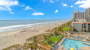 Un complejo turístico frente a la playa con piscina y vistas al océano.