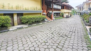 A cobblestone street lined with traditional buildings, some with balconies and potted plants. - OYO 92088 171 Inn (Bogor)