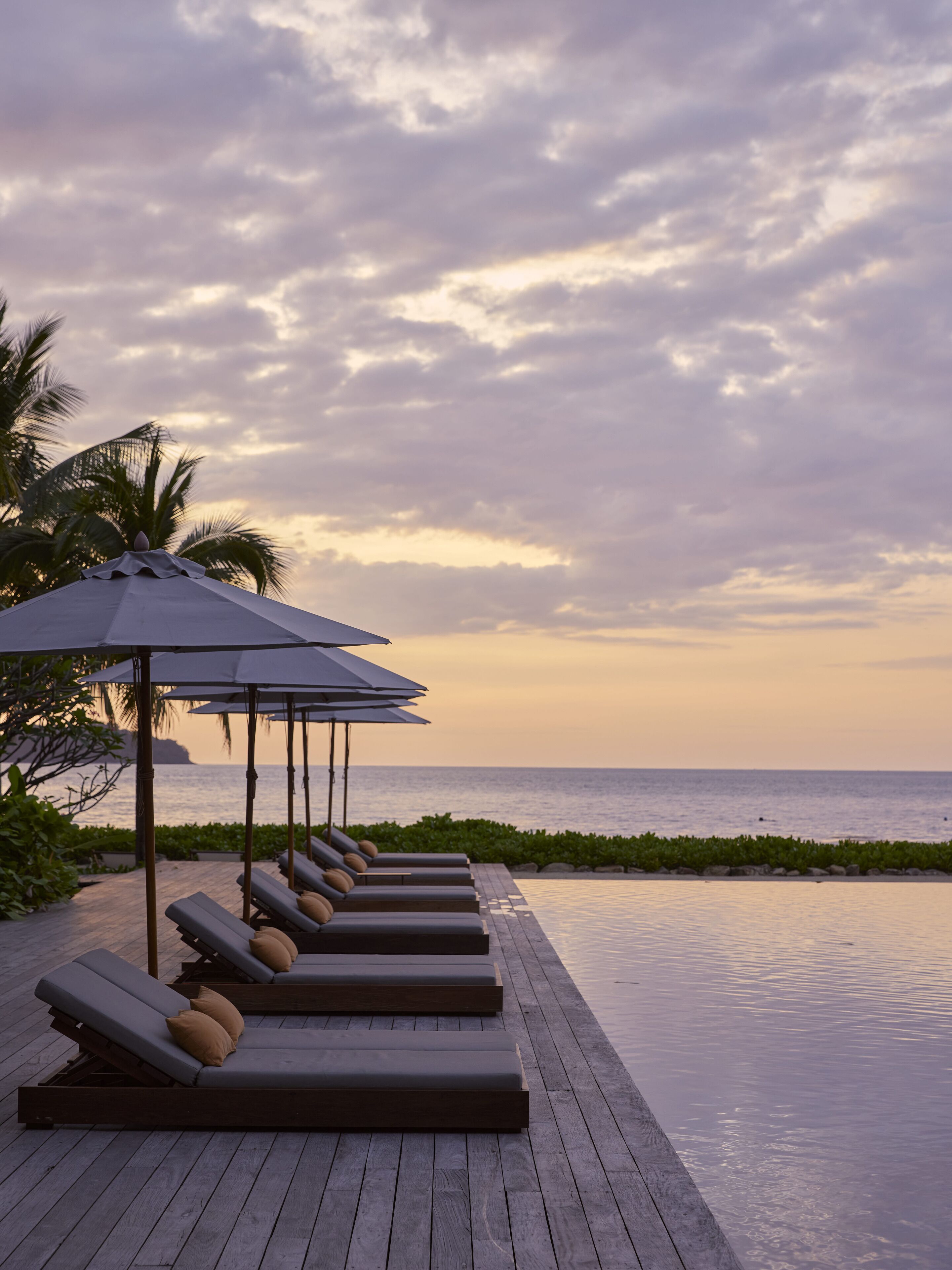 Una piscina al aire libre, camas de piscina gratis, sombrillas