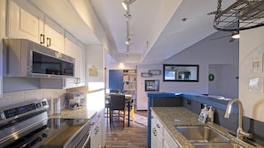 A modern kitchen with stainless steel appliances, granite countertops, and a built-in oven. - Park City Mountain View Condo | Amazing Ski Location! (Park City)