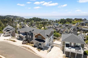 A residential area with houses featuring modern architecture, a clear view of the sea, and a well-maintained landscape.