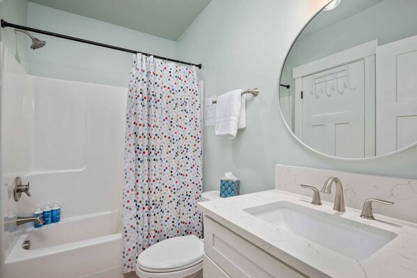 A bathroom with a bathtub, toilet, and sink.