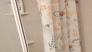 A bathroom with a shower curtain featuring a floral pattern. - Jardines Canarios 2 (Los Cristianos)