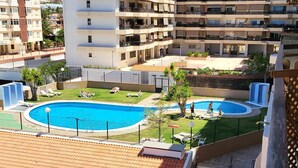 A residential building with a rooftop pool, multiple balconies, and surrounding greenery. - Jardines Canarios 3 (Los Cristianos)