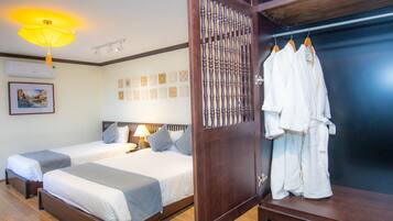 A hotel room with two beds, a wardrobe, and a hanging robe rack.