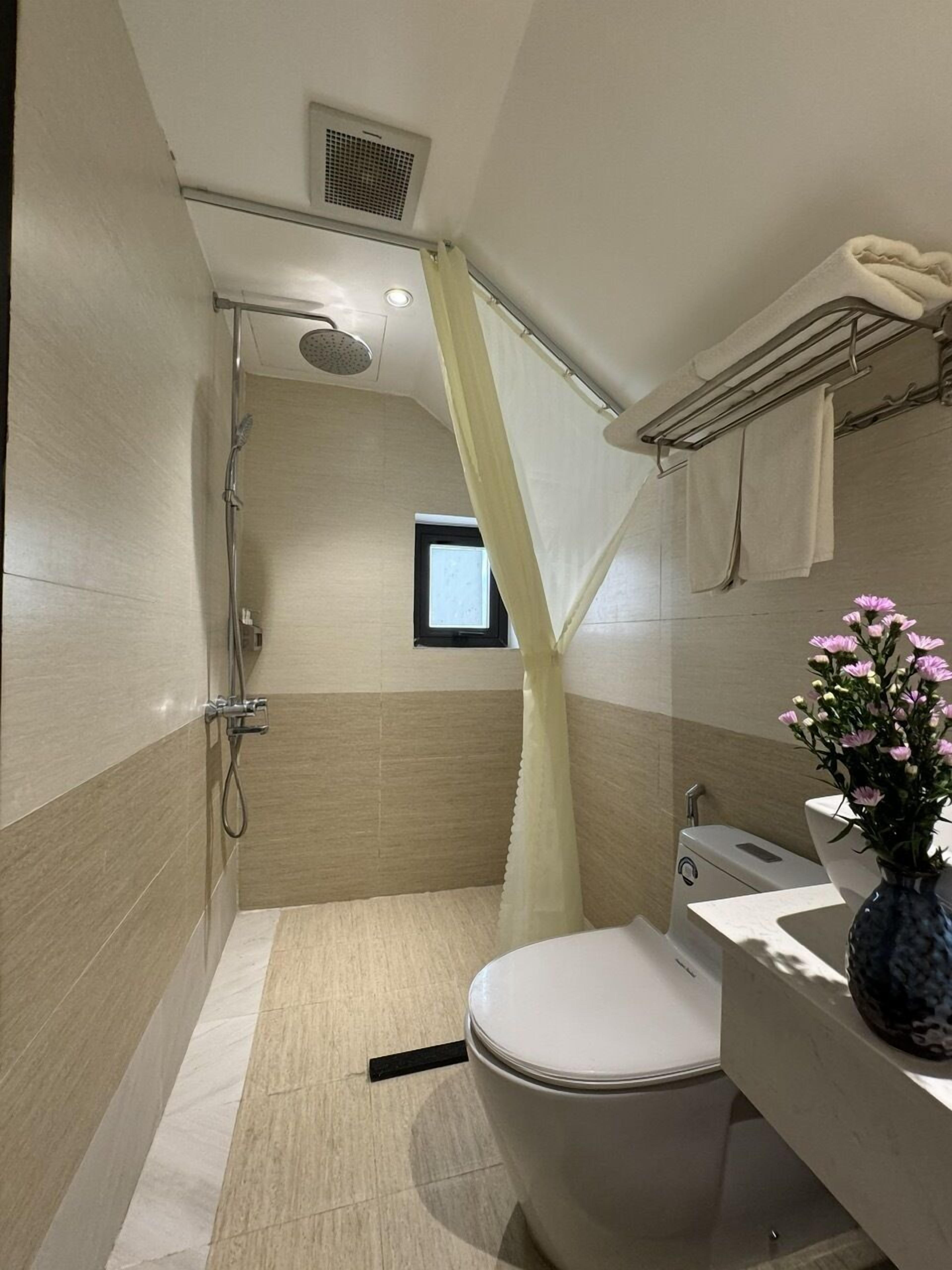 A modern bathroom with a shower, toilet, and sink.