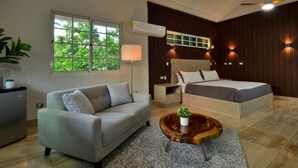 A modern bedroom with a bed, a sofa, a coffee table, and a desk. - Tortuga Bay Villa - Close to the Beach and Golf (Punta Cana)