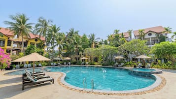 Alberca al aire libre, sombrillas en la alberca y camastros