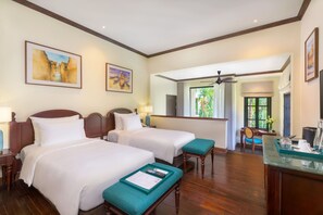 Habitación de hotel con dos camas, un escritorio y vistas al exterior.