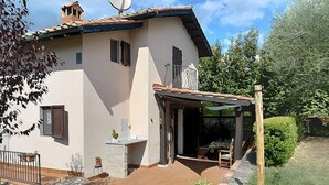A two-story house with a patio, a small garden, and a wooden fence. - Casa Binetta A: A characteristic and welcoming two-story independent house situated in the heart of the Tuscan countryside. (Santa Fiora)