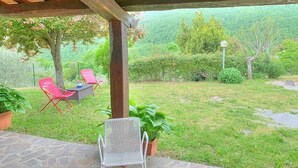 A covered patio with two chairs, a table, and potted plants. - Casa Binetta B: A characteristic and welcoming two-story independent house situated in the heart of the Tuscan countryside. (Santa Fiora)