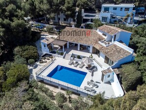 Une grande villa moderne dotée d’une piscine, de plusieurs espaces de détente extérieurs et d’un vaste patio.