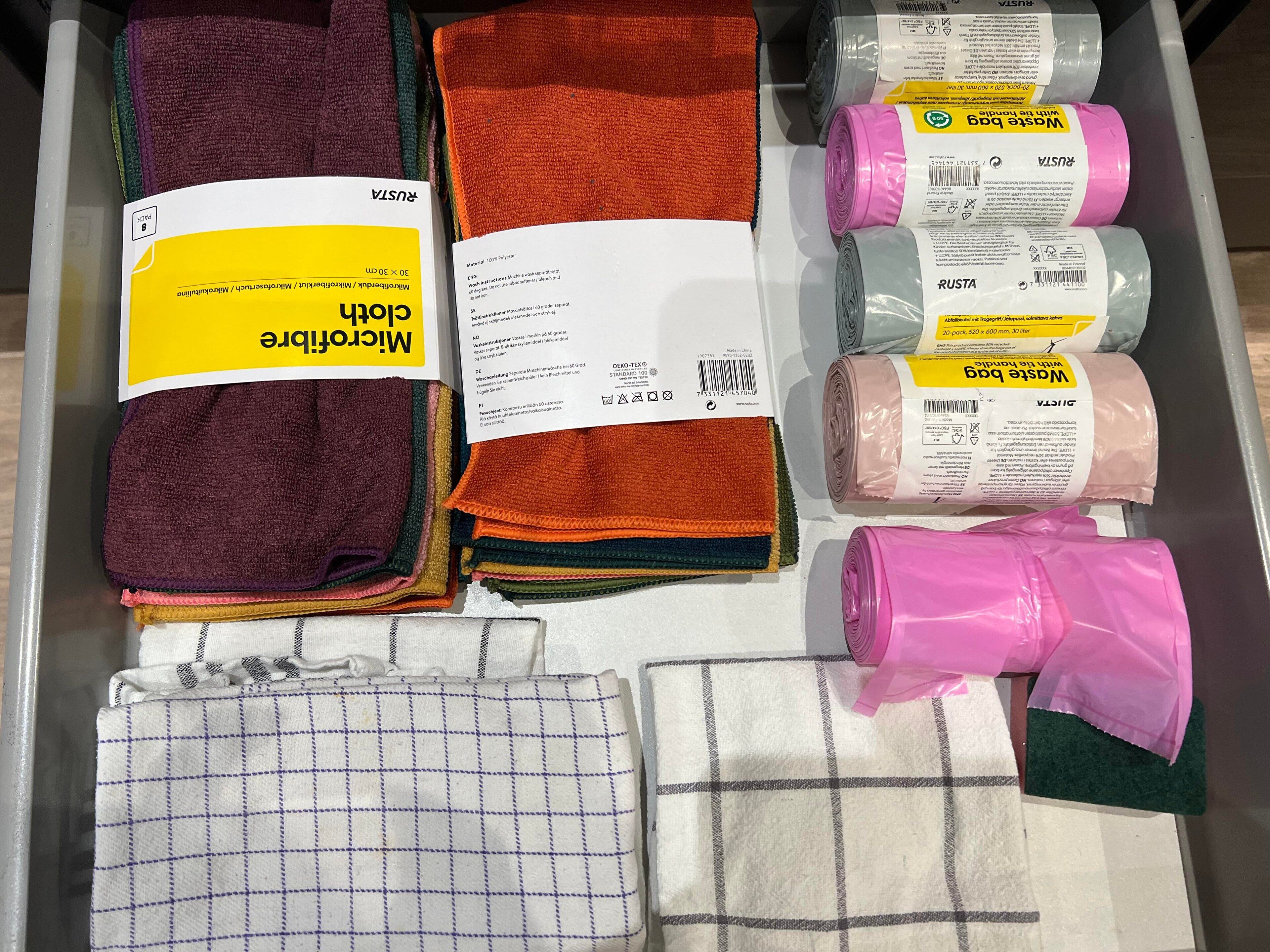 A storage area with various folded towels and bath mats in different colors and patterns.