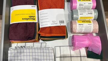 A storage area with various folded towels and bath mats in different colors and patterns.