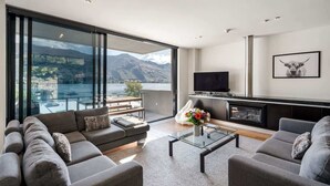Una sala de estar moderna con un ventanal grande, un televisor de pantalla plana y una chimenea.