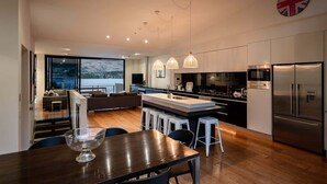 Una cocina moderna con una isla central, electrodomésticos de acero inoxidable e iluminación colgante.