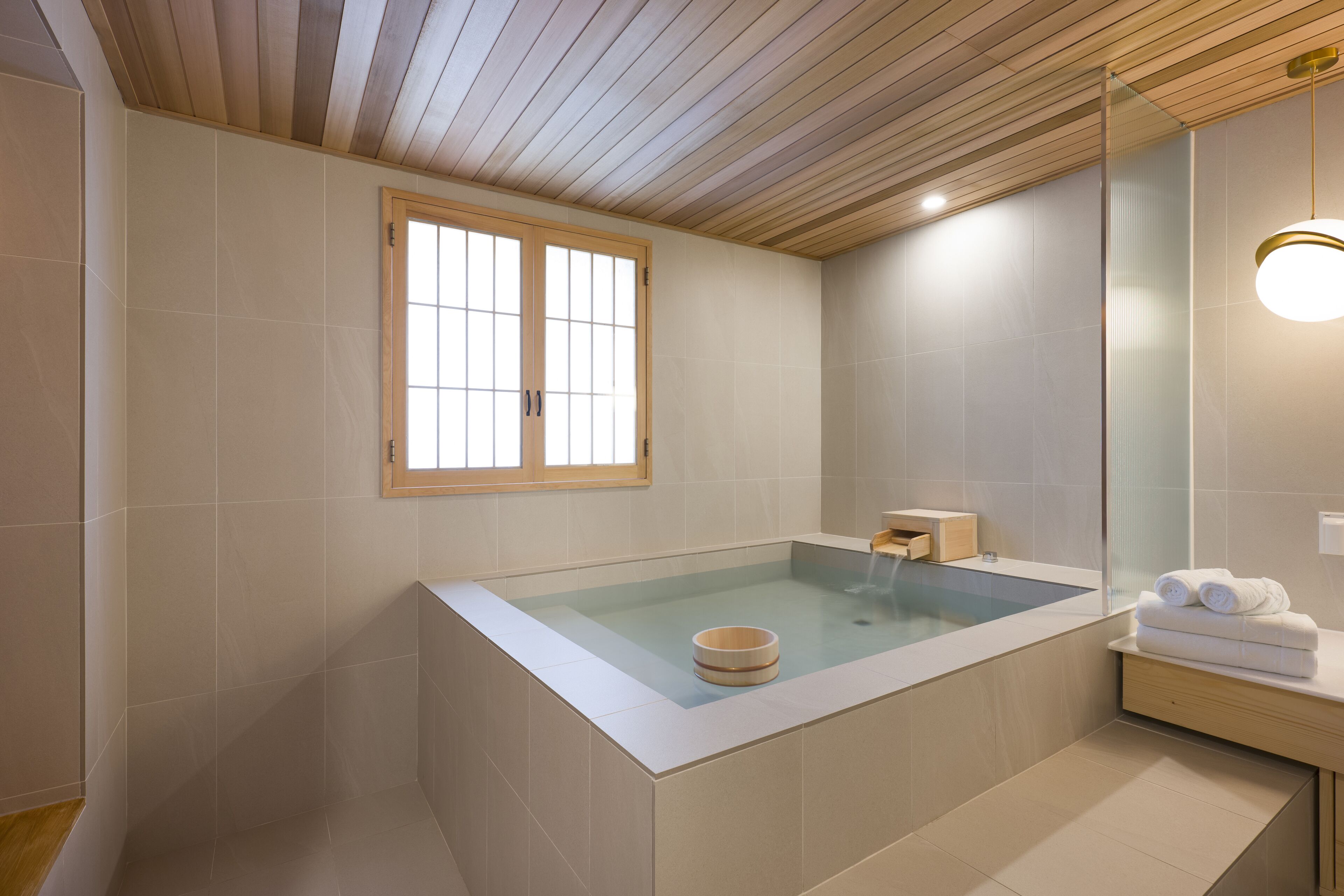 Une salle de bain moderne avec une baignoire sur pieds, un meuble-lavabo en bois et un grand miroir.