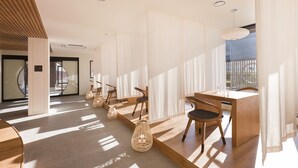 A modern interior with a wooden reception desk, wicker lamps, and a view of the outdoors. - HOTEL YUSURIM (Changwon)