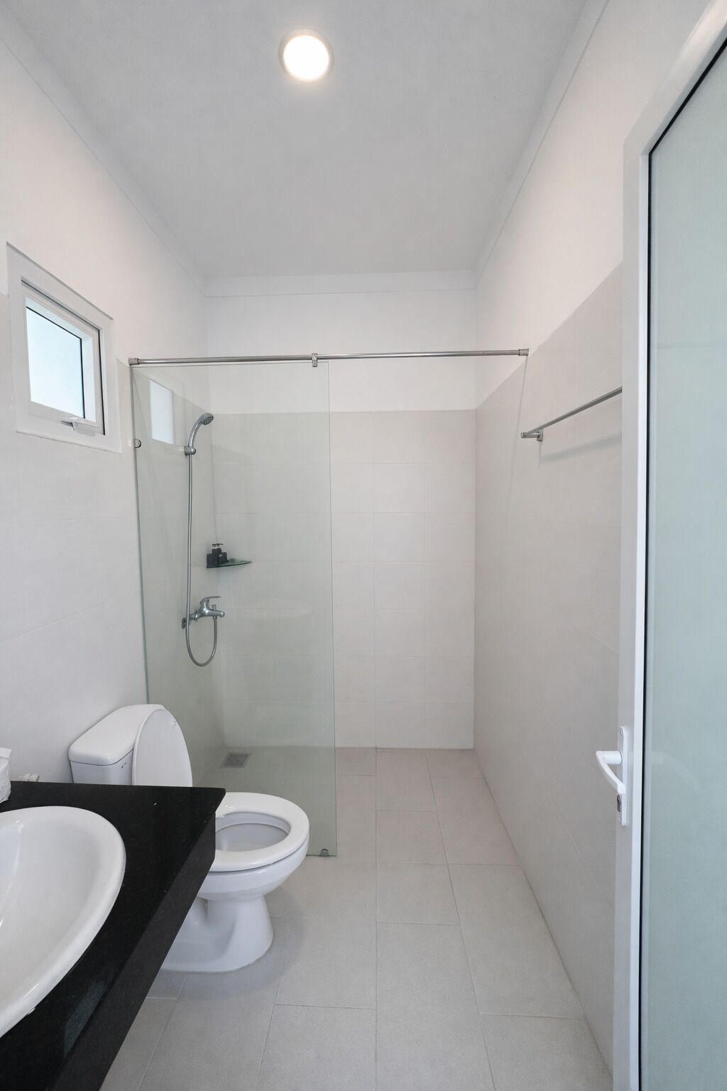 Un baño moderno con cabina de ducha de vidrio, inodoro y lavabo.
