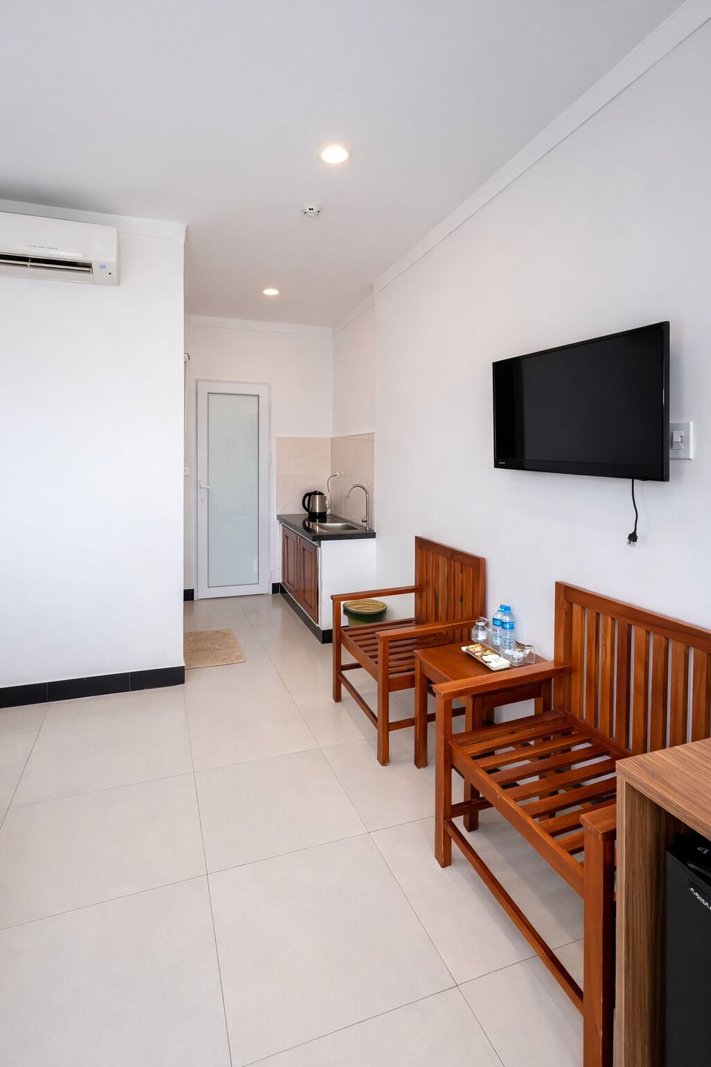 Una cocina moderna con un lavabo, estufa y un televisor de pantalla plana montado en la pared.