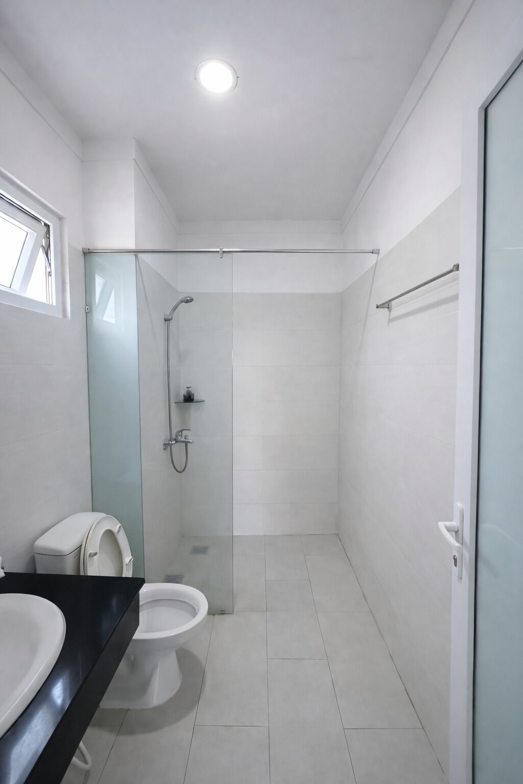 Een moderne badkamer met toilet, douche en hygiëneslot.