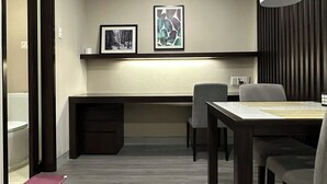 A modern dining area with a long table, chairs, and a hanging light fixture.