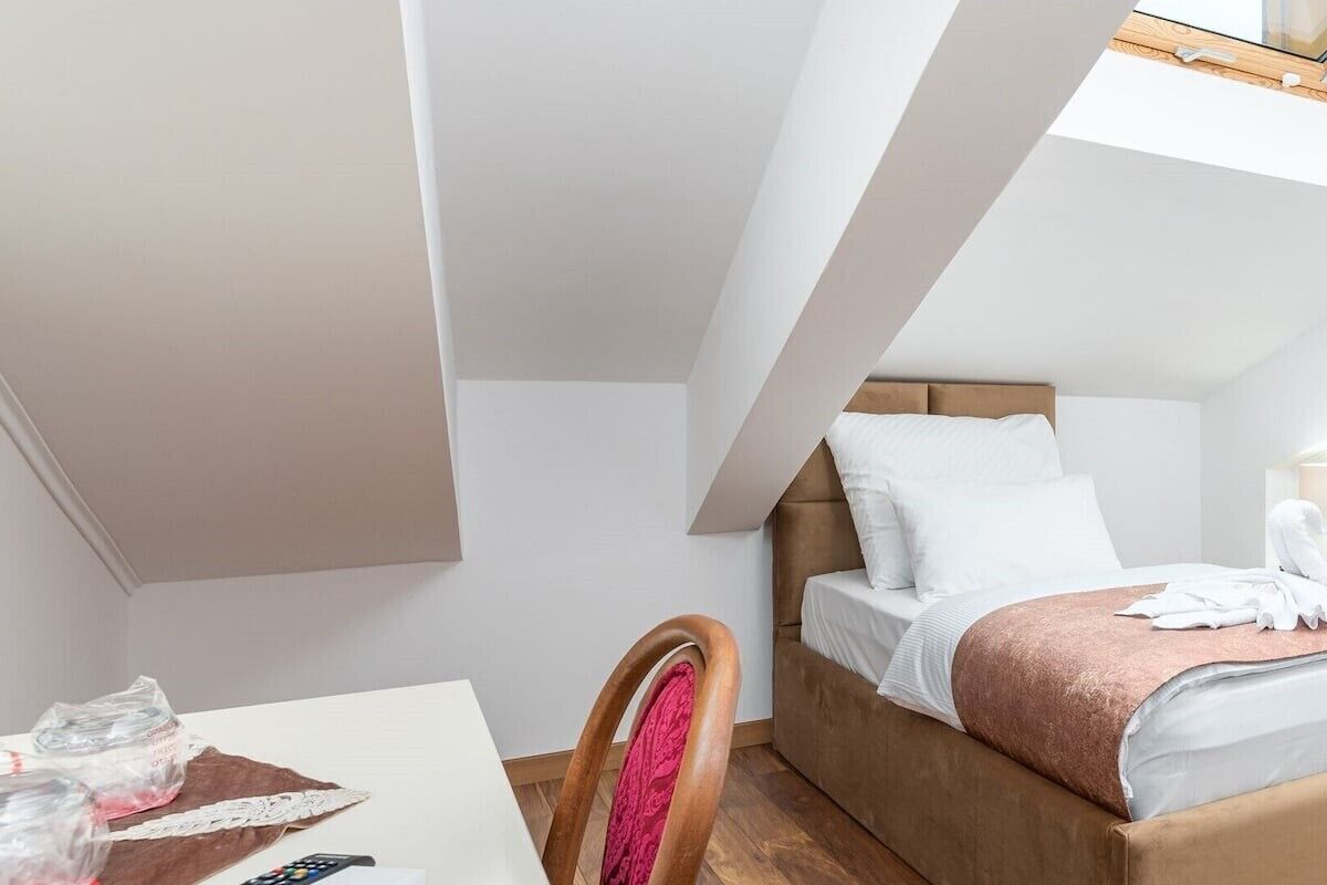 Ein Schlafzimmer mit Bett, Schreibtisch und Stuhl.
