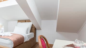Un dormitorio moderno con cama estilo loft, suelo de madera y comedor con mesa y sillas.