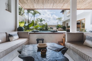 Relax in a serene outdoor space with a comfortable sofa and natural surroundings.