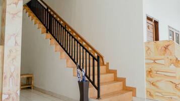 Una escalera con escalones de madera y barandillas negras que conduce a un piso superior.