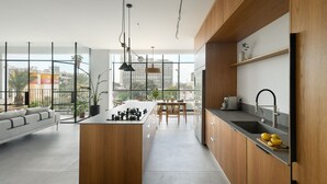 Een moderne keuken met een centraal eiland, houten kastjes en een groot raam met uitzicht op de stad.