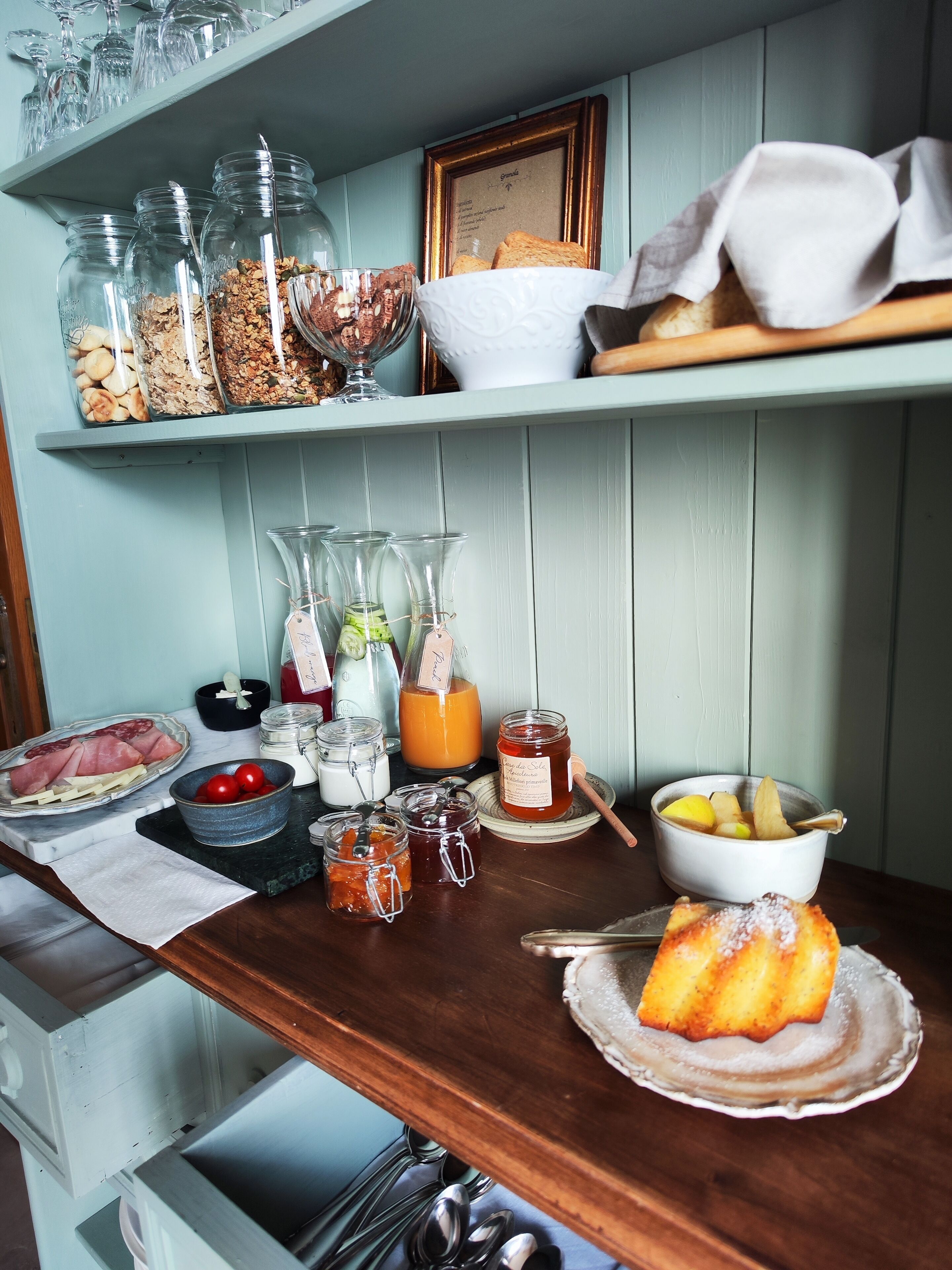 Una mesa de desayuno con diversas opciones de comida, como pan, fruta y salsas.