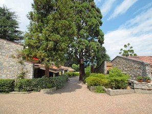 A stone building with a paved pathway leading to a covered entrance.