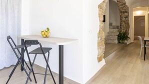 A modern kitchen with a white countertop, two black chairs, and a bowl of lemons. - Il Giardino by Interhome (Terzorio)
