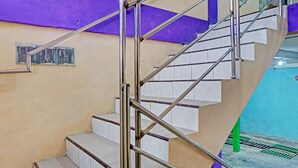 Un escalier avec des rampes en métal et des marches blanches.
