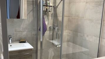 Chuveiro, secador de cabelo, toalhas de banho, sabonete