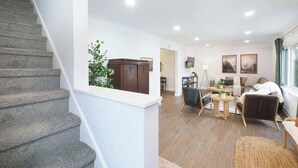 Un intérieur moderne comprenant un escalier, un coin repas et un salon.
