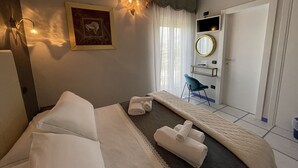 Ein Hotelzimmer mit Bett, Schreibtisch, Stuhl, Spiegel und einem Gemälde an der Wand.