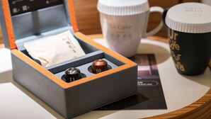 A display case with two items, a box, and a card.