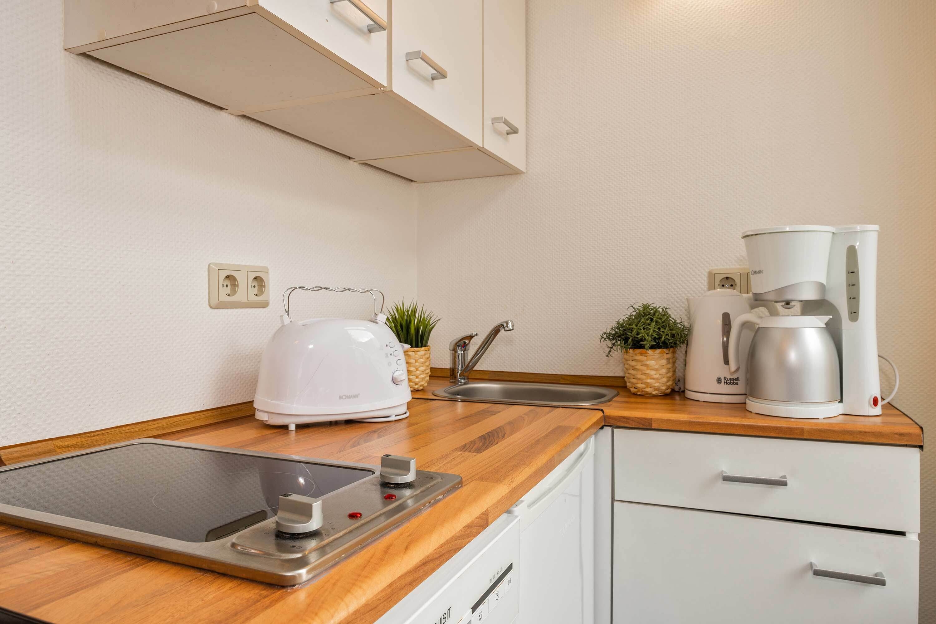 Cafetera o tetera, frigorífico, microondas y placa de cocina