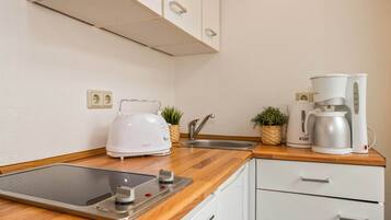 Cafetera o tetera, frigorífico, microondas y placa de cocina